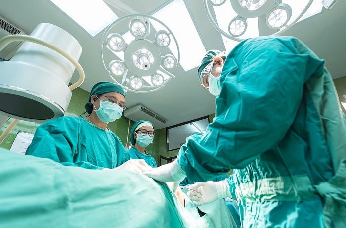 Lékaři zavádějí při operaci drén.
